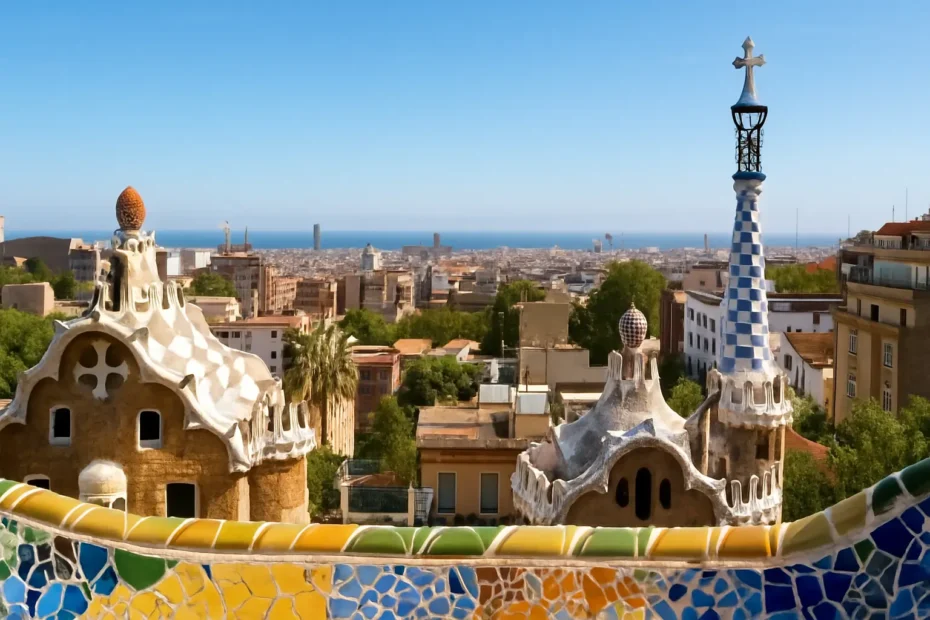 Vista panorâmica do Parque Güell com a Sagrada Família ao fundo em Barcelona, céu azul e mosaicos coloridos em destaque