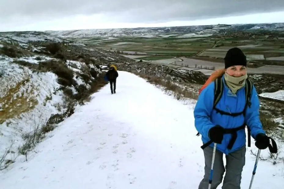 Camino de Santiago en invierno con peregrino caminando bajo frío, lluvia y silencio en Galicia