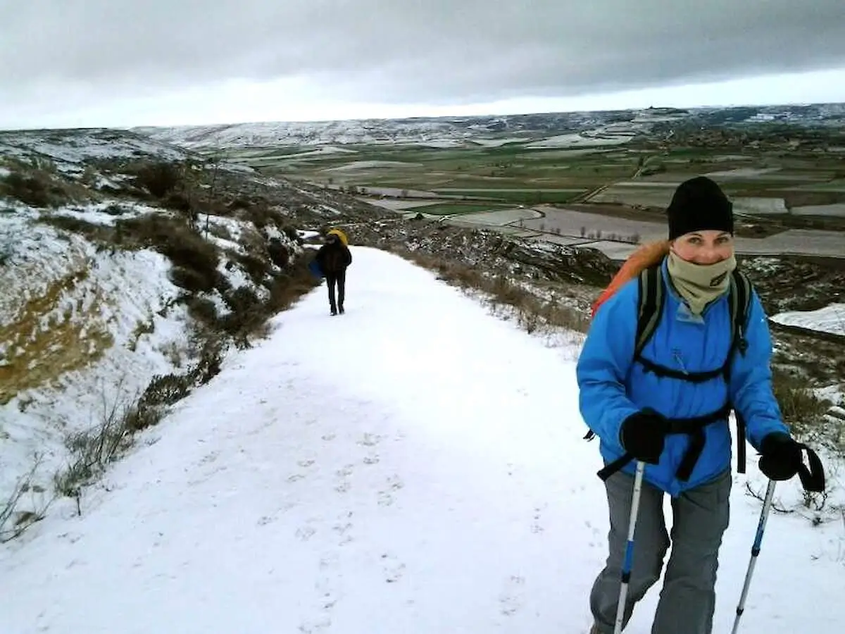 Camino de Santiago en invierno con peregrino caminando bajo frío, lluvia y silencio en Galicia